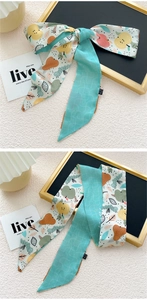 Détail de l'imprimé fruits et motif à vagues vert menthe sur long ruban de soie