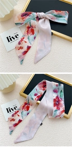 Détail d'un foulard étroit en soie avec motif floral de peinture à l'huile pour cheveux