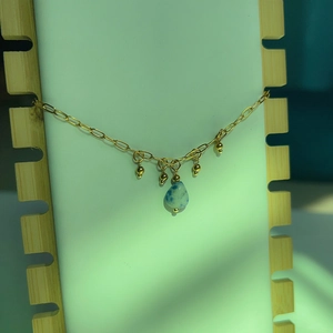 Détail du bracelet en acier titane doré 18K avec pierre naturelle et perles fines