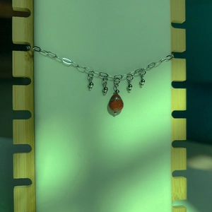 Détail d'un bracelet vintage en or 18 carats avec pierre goutte et pompon en perle