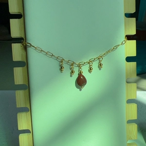 Détail du collier plaqué or 18 carats avec pierre en goutte et perles dorées fines