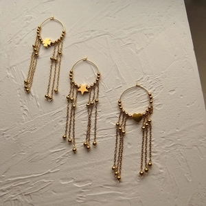 18K gold plated tassel hoop earrings with clover star and heart charms on white textured base