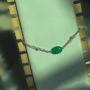 Detail of vintage double-layer bracelet with oval green stone and silver chain
