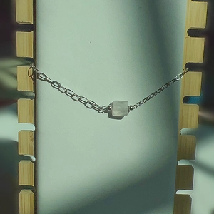 Détail d'un bracelet en argent avec pendentif carré en quartz blanc facetté élégant