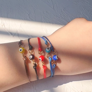 Set of four woven Evil Eye bracelets in red, black, brown and navy with gold accents