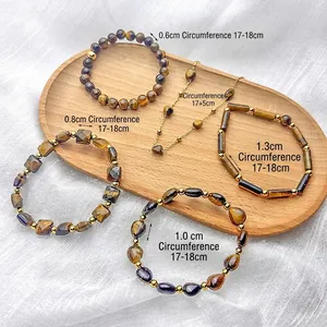 Vintage tiger eye stone beaded bracelets and necklace set on a light wooden tray