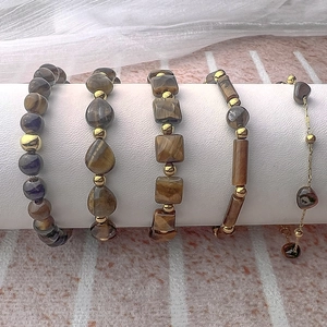 Five-piece vintage tiger eye stone beaded bracelet set with golden accents on a display