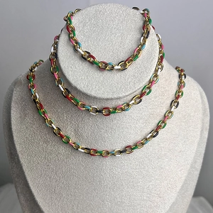 Fashionable rainbow enamel gold link chain necklace displayed on a gray jewelry stand
