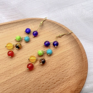 Gros plan détaillé de boucles d'oreilles chakra en pierres sur plateau en bois