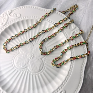 Macro view of multi-color enamel gold chain with lobster clasp and extension details
