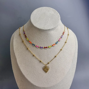 Detail of 18K gold layered necklace with colorful enamel butterflies and evil eye heart