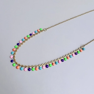 Macro detail of colorful enamel charms on 18K gold double layer necklace chain