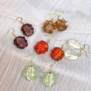 Boucles d'oreilles colorées en verre ondulé avec crochets dorés sur tissu blanc