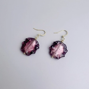 Détail de boucles d'oreilles en verre violet avec feuille d'argent et crochets dorés