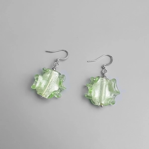 Vue détaillée des boucles d'oreilles en verre vert clair avec texture plissée