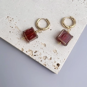 Vue détaillée de boucles d'oreilles rétro en acier doré avec pendentif carré rouge