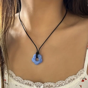Bohemian wax rope necklace featuring a blue resin flower pendant on a model
