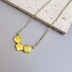 Détail de la chaîne en acier doré 18K avec fleurs en pierre œil de chat jaune