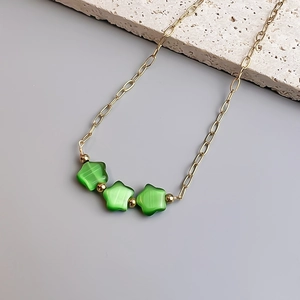 Détail de la chaîne en or 18K avec perles étoiles en œil de chat vert et fleurs