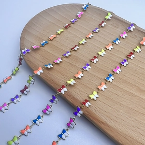 Buntes Schmetterlings Schmuckset mit Goldketten auf einem runden Holztablett