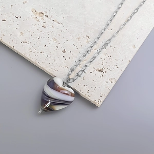 Detail of artistic purple heart glass pendant on a silver chunky link chain necklace