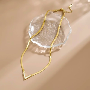 Gold stainless steel herringbone necklace featuring a V-shaped white shell pendant