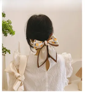 Détail d'un ruban à cheveux en soie à motif citron noué en nœud sur un chignon