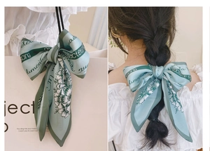 Foulard en soie vert menthe utilisé comme accessoire de sac et ruban pour cheveux