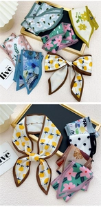 Gros plan de divers foulards twilly en soie aux motifs floraux et artistiques variés