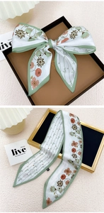 Détail d'un foulard en soie étroit avec motifs floraux rétro et lettrage love chic