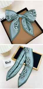 Détail d'un foulard en satin bleu à fleurs avec dessin au trait et bordure élégante