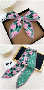 Détail d'un élégant foulard en soie verte avec imprimé floral et bordure violette