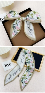 Gros plan du foulard en soie à fleurs crème noué en nœud avec une bordure kaki élégante