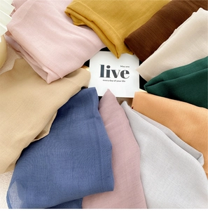 Flat lay of colorful diamond scarves in various pastel tones with woven texture