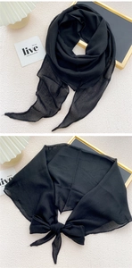 Detail of a lightweight black diamond-shaped chiffon scarf tied in an elegant large bow
