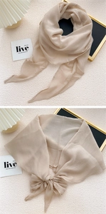 Close-up of lightweight beige chiffon scarf tied in a bow with soft fabric texture