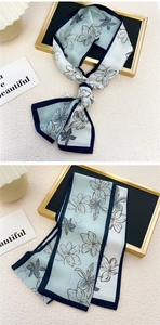 Détail macro d'un foulard étroit en soie bleu clair avec motif de lys fleuri