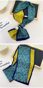 Détail d'un foulard étroit en soie double face avec poissons jaunes et motifs bleus