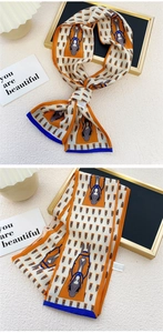Vue détaillée d'un foulard étroit en soie à motifs de têtes de chevaux orange et bleu