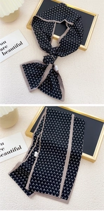 Détail d'un twilly noir étroit avec des motifs en V blancs et un ourlet gris