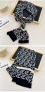 Détail d'un foulard étroit en soie noir et blanc avec motifs géométriques de lettres