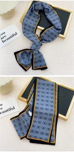Détail d'un foulard twilly bleu gris avec imprimé papillon et bordure passepoilée