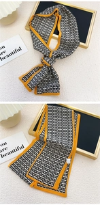 Détail macro d'une écharpe en soie étroite avec motifs géométriques noirs blancs et orange
