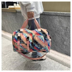 Detail view of large travel bag with aurora pattern held by model in modern setting