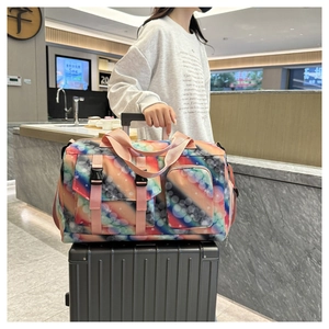 Travel bag with galaxy print secured on luggage handle for convenient airport transit