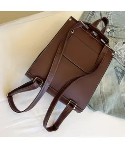 Detail of dark brown leather backpack back with adjustable straps and white stitching