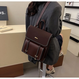 Detailed close-up of dark brown vintage PU leather backpack with white stitching details