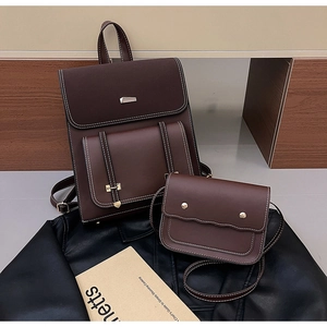 Detail view of brown PU leather backpack and matching crossbody bag with white stitching