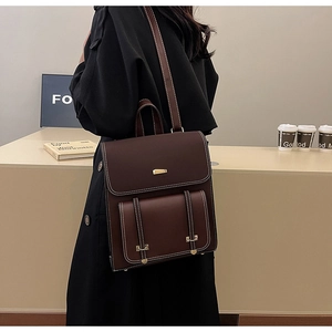 Detail of vintage PU leather backpack with contrast stitching and metallic gold buckle