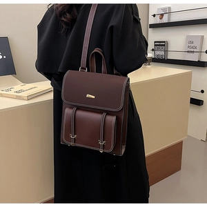 Detail of retro dark brown PU leather backpack featuring white contrast stitching and pocket
